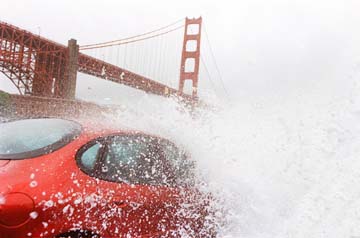 wave crashing over a car parked near Golden Gate Bridge