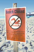 photograph showing a beach closed to swimming sign at Huntington Beach