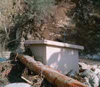 Figure 3 is a photograph showing debris covering East Twin Creek streamgage.