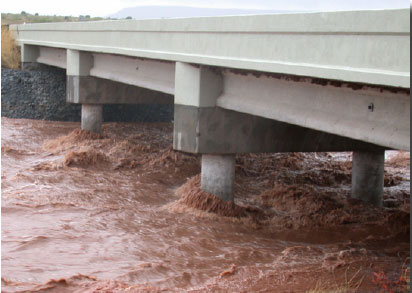 Figure 1. Photograph showing near peak flow in an ephemeral stream near Variadero, N. Mex. (Garita Creek at Highway 104 Bridge), September 9, 2002.