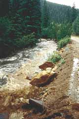 Photo showing flooding and erosion in a mountain valley.