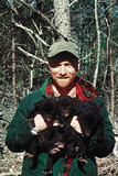 Photo of a man holding a baby black bear.