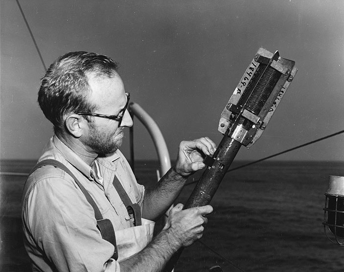 Dr. Robert H. Meade, USGS Marine Scientist, inserts a smoked glass slide into a bathythermograph (BT). This instrument, familiar to all ocean researchers, records water temperature at various depths on the smoked glass slide. Meade is pictured here aboard the Research Vessel GOSNOLD, owned and operated by the Woods Hole Oceanographic Institution. This vessel has been used extensively by the WHOI - USGS team of scientists who are studying the geology of the Atlantic Continental Shelf and Slope.
