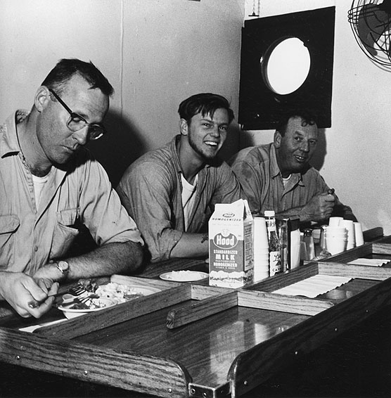 Suppertime aboard the Research Vessel GOSNOLD is observed here by the vessel's First Mate, Sam Vincent (left), Seaman Earl "Skip" Moody (center), and Engineer Ted Seifert during a cruise to the edge of the Continental Shelf. The crew provides valuable support to the marine scientists working on board - not only in the operation of the ship, but in lending a hand with scientific instruments, winches, etc.  Since 1962, the USGS in cooperation with the Woods Hole Oceanographic Institution for geologic studies along the Atlantic Continental Shelf and Slope.