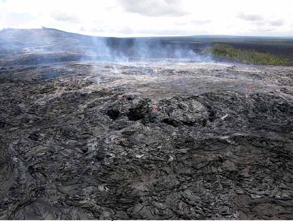 Looking back toward Pu‘u ‘Ō‘ō, a perched lava pond was forming over fissure D in this July 23, 2007 photo. Pu‘u Kahauale‘a is the vegetated cone behind the perched pond (from figure 4)