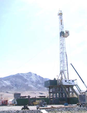 photo of large drill rig in a desert valley with a desert peak in the background