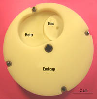 Figure 7. A bottom view illustrating the capture of a disc by the rotor mechanism and movement to the drop hole of the end cap. The rotor then travels to the drop hole of the end cap and the disc is released by gravity.
