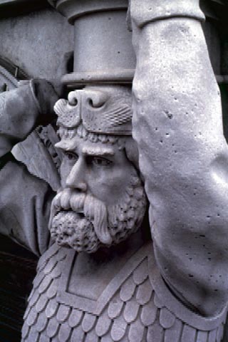 photograph of statue of an armored knight with beard and lion-head hood