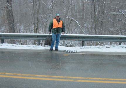 Hydrologis examines a highway storm drain during a winter storm.