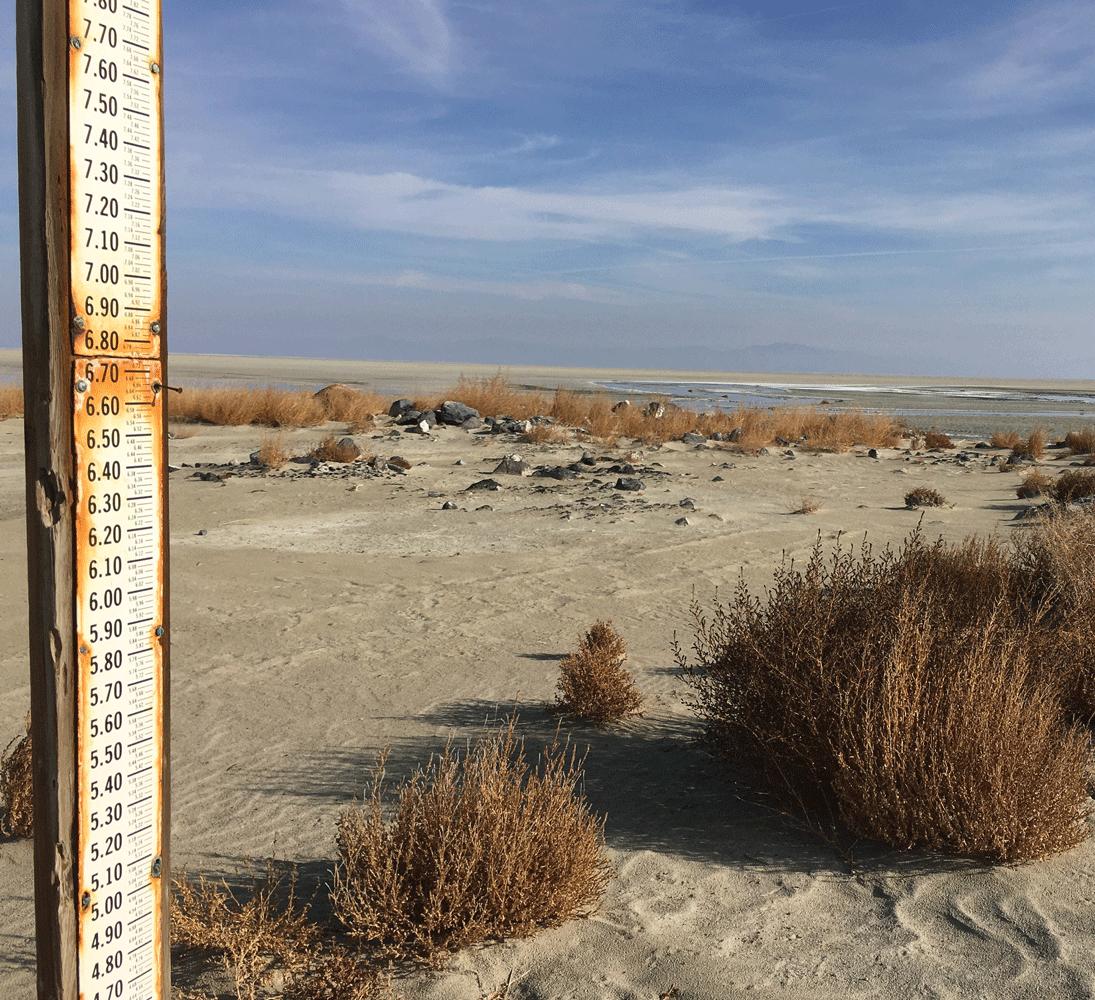 A water-level gage sits in a dried lake bed.