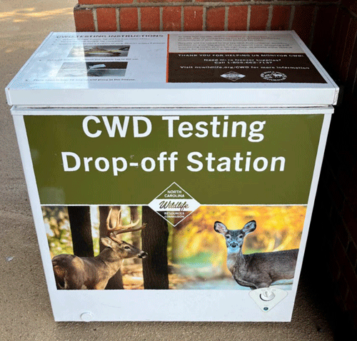 White box with images of deer and labels on it, indicating this is a drop-off station
                  where samples can be collected.