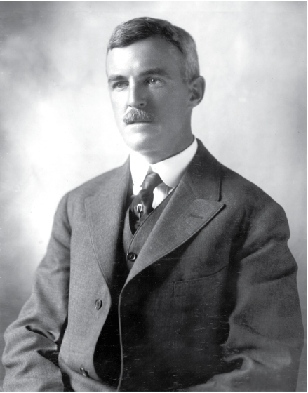 Black and white portrait image of a man in a suit.