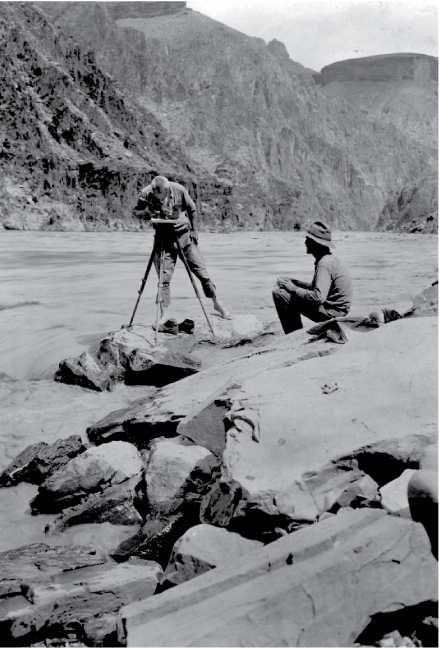 One man works with a planar-table tripod and alidade while another is seated. A tall
side of the gorge dominates the image.