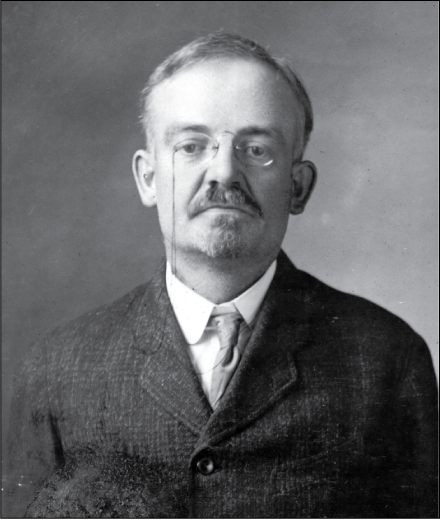 Portrait image of a man in a suit with glasses and a goatee facing the camera.