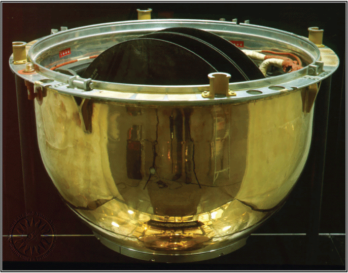 Gold, reflective, bowl-shaped object with mechanical fittings on the rim. Electromechanical
elements protrude from within.