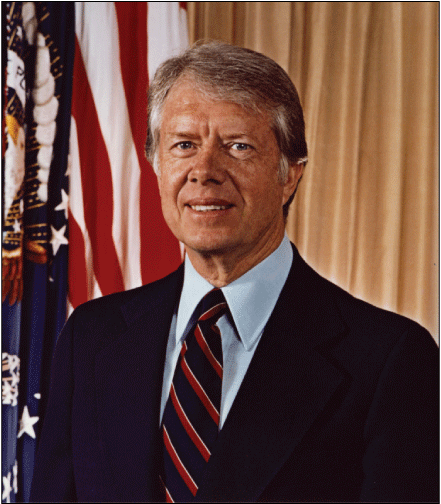 Portrait image of the President standing near a flag of the United States.
