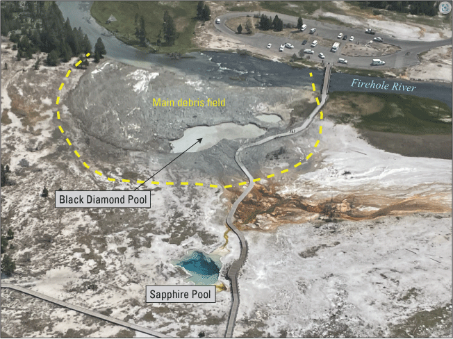 25. A barren landscape with a few trees and thermal pools, a river flowing nearby,
and a parking lot.