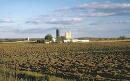 Picture of farm building in the middle of a field.