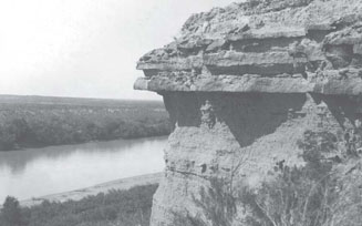 Photograph shows the Cretaceous-Paleocene contact on the Rio Grande River at White Bluff, about 5 mi from the Webb County line, in Maverick County, Texas.  [Photograph by L.W. Stephenson, 1912 (U.S. Geological Survey Professional Paper 90-J)]