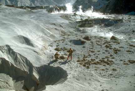 Photograph of pyroclastic-flow deposits with geologist in middle ground