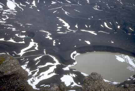 Photograph from air of lake-filled maar crater on caldera floor and light snow cover