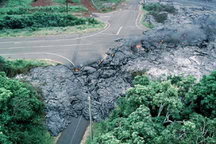 photo 035.  Low-elevation oblique aerial photo of lava flow that has crossed paved roads and blocked them