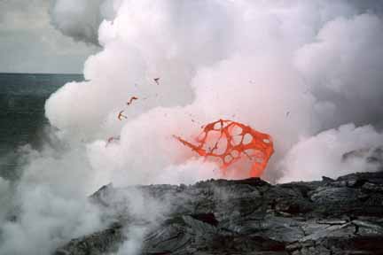 photo 048.  Photo of thin, delicate red-hot lava spatter with steaming ocean behind it