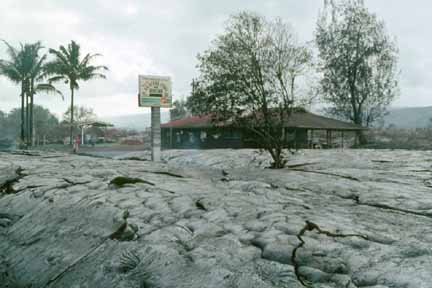 photo 071.  Photo of small store surrounded by lava.  Sign on three-meter-tall post out front