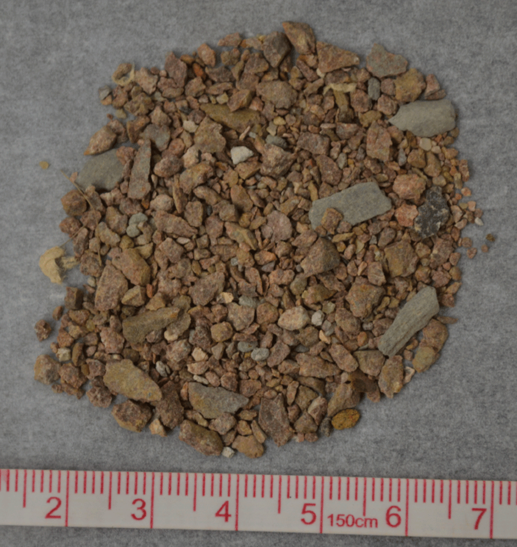 A pile of cuttings is shown next to a ruler for scale.