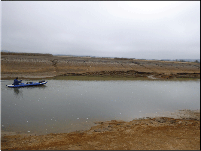 Example of channel banks and wetted channel along Coyote Creek surrounded by undifferentiated
reservoir floor within Fern Ridge Lake, Oregon. Banks in this section of Coyote Creek
show erosion by calving failures and rilling from dewatering of the reservoir floor.
Photograph taken by Mackenzie Keith, U.S. Geological Survey, February 8, 2022.