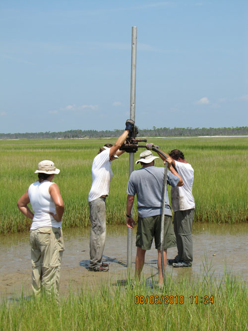 Photo showing terrestrial vibracore collection on Cat Island with motor vibrating core into ground