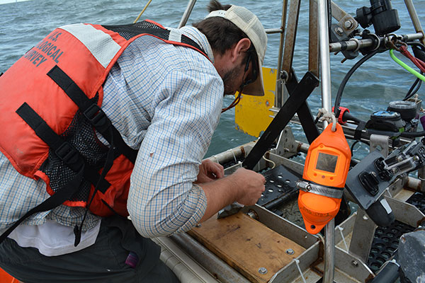 Photograph of a surface sediment sample being collected from the Miniature Sea Bed Observation and Sampling System (miniSEABOSS) off of Dauphin Island, Alabama.