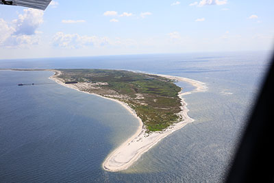 Oblique aerial photograph looking east-southeast at Ship Island showing Fort Massachusetts and the pier, September 2016