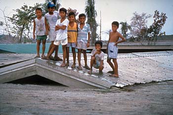children on top of their schoolhouse that has been buried by mudflows