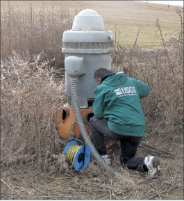 Photograph of USGS hydrologic technician measuring the water level