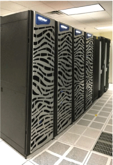 Photograph shows a row of supercomputers that are nearly as tall as the ceiling of
                     the office where they are stored.