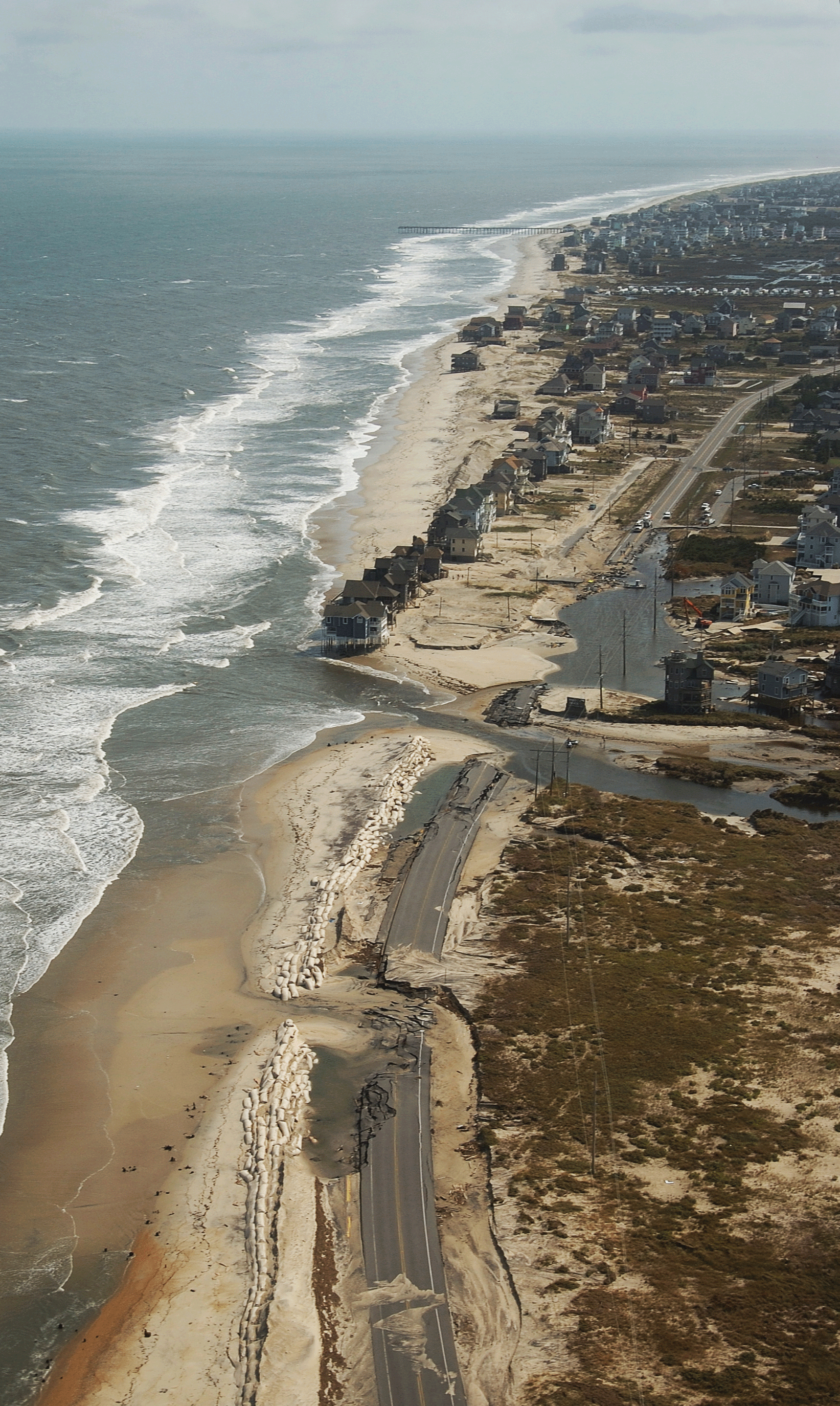 A section of highway contains damaged and washed away sections near the coastline.