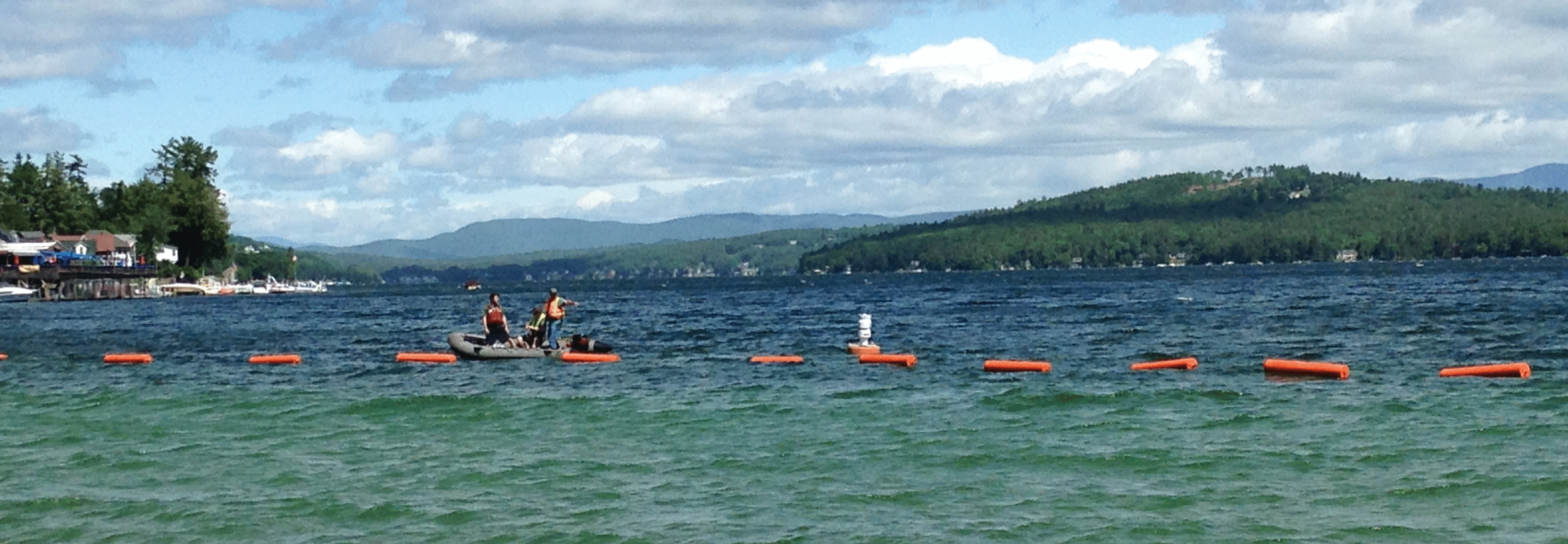 Photograph of buoys stretched across a section of Lake Winnipesaukee.