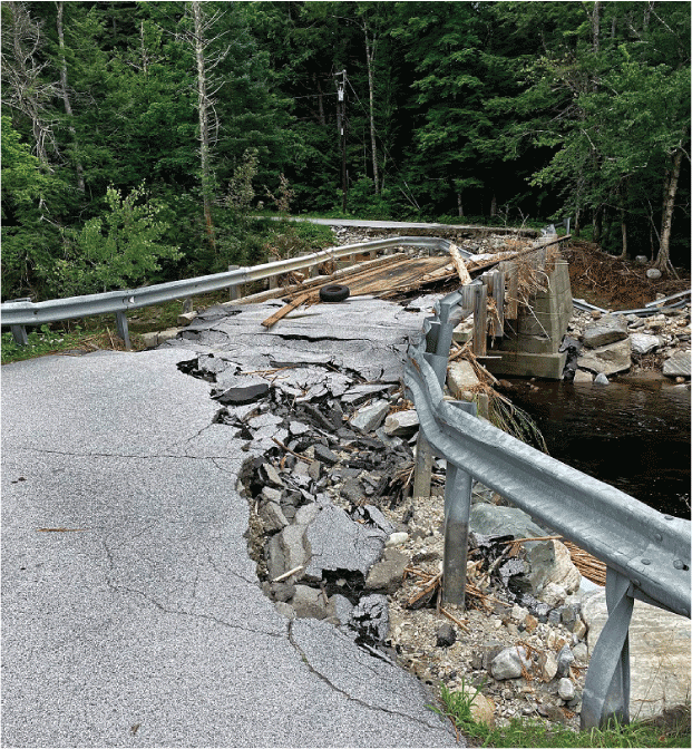 A bridge is severely damaged from flooding.