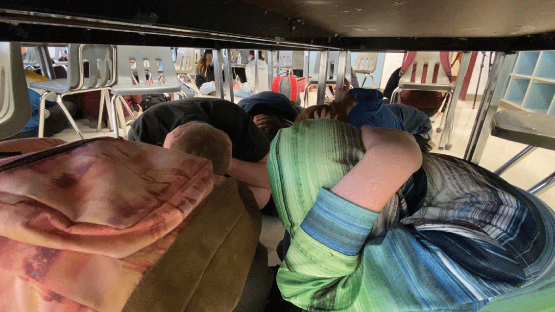 Students under desks during an emergency earthquake drill.