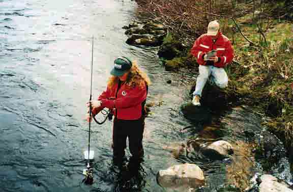 Photo of field technicians taking a discharge measurement with a current meter.