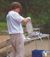 Photograph of USGS hydrologist Marcus Gary collecting suspended sediment at Main Barton Springs.