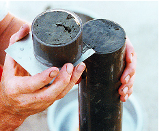 Photograph showing hydrologist slicing a subsample from a core for laboratory analysis.