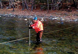 Photo of a USGS researcher making a streamflow measurement in the Green River near Colrain, Massachusetts