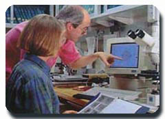A color photograph of a man and woman studying a computer screen. Photo: ODP/TAMU Photography Department