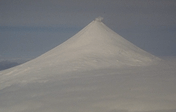 Figure 9. Symmetric Shishaldin Volcano rising 2,857 m (9373 ft) above sea level. Fumarolic activity within the summit crater produces a nearly continous plume of steam.