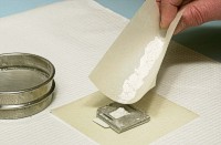 Pour excess powder from first weighting paper into sample holder.