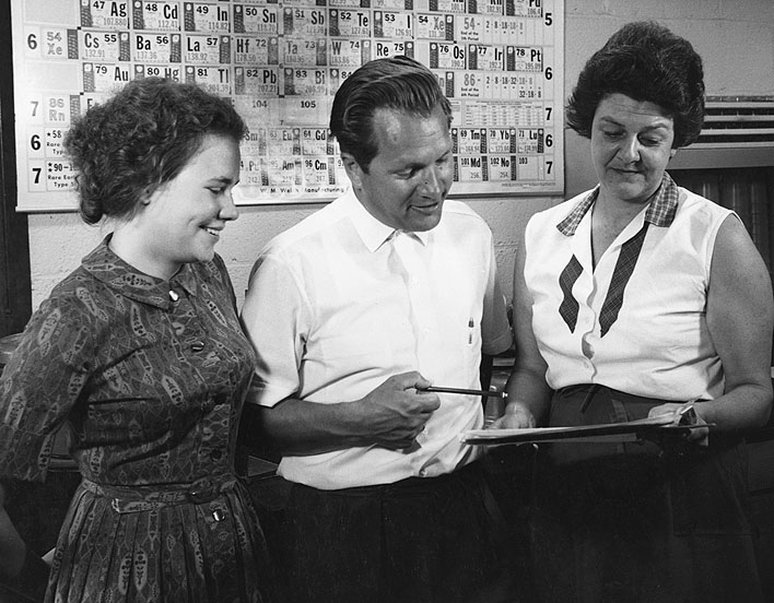Dr. Jobst Holsemann, WHOI, (center) who supervises the chemical analyses of sediments from ocean areas confers here with his assistants, Miss Paula A. Wiercinska (left), and Mrs. Medlyn Hamilton (right).