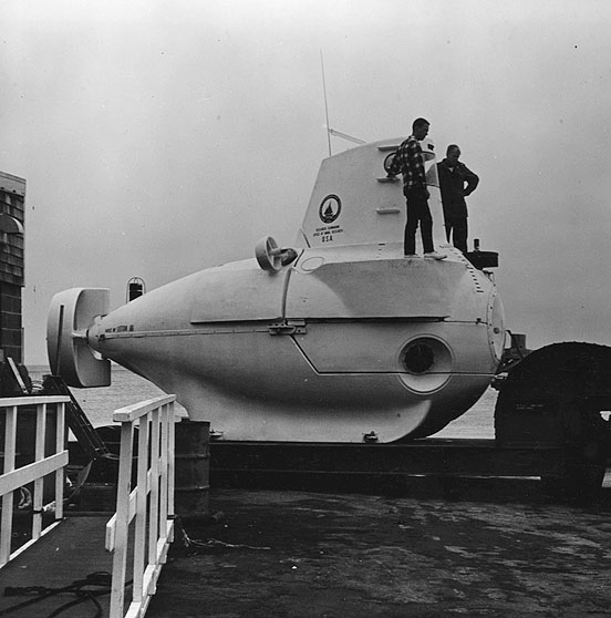 ALVIN is a deep-diving research vehicle, designed specifically for ocean research by the Woods Hole Oceanographic Institution.  It is 22 feet long, has a displacement of 13 long tons, and a top speed of 6-8 knots.  Its design operating depth is 6,000 feet.  The 7-foot pressure sphere is 1.33 inch thick steel.  It will carry a pilot and one or two scientists.
