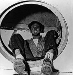 Scooting down the ladder from the fantail to the galley, Seaman Earl "Skip" Moody is surprised by the photographer's flashgun. 